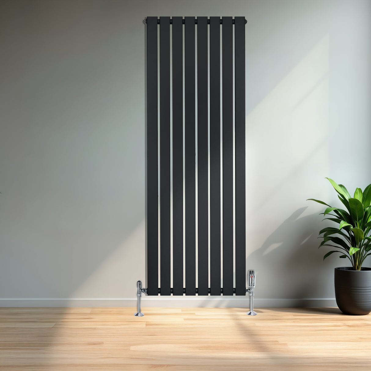 Radiador de columna única negro, 1600 mm x 560 mm, con diseño vertical y acabado liso, instalado en una pared clara junto a una planta decorativa