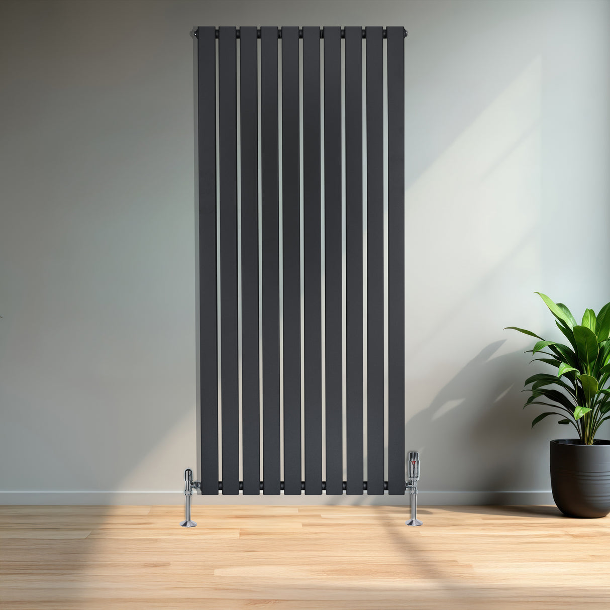 Radiador de columna única en gris antracita, con diseño vertical y acabado liso, instalado en una pared con suelo de madera clara