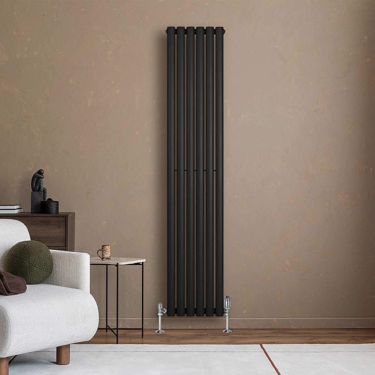 Radiador de columna ovalado negro de 1800 mm x 360 mm, con un diseño elegante y moderno, instalado en una pared beige junto a un sofá claro